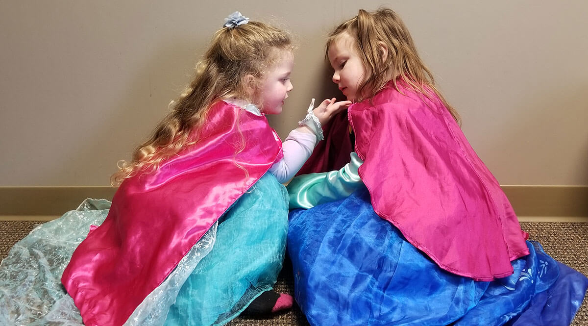 two girls play dress up together