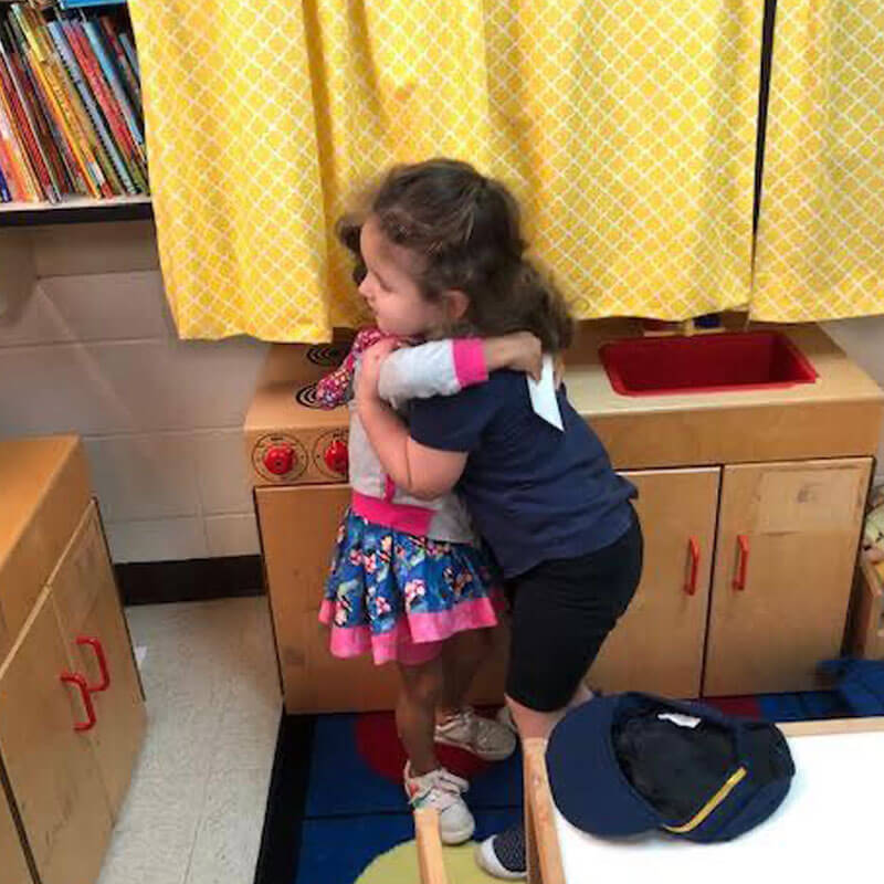 Girls giving hugs in school.