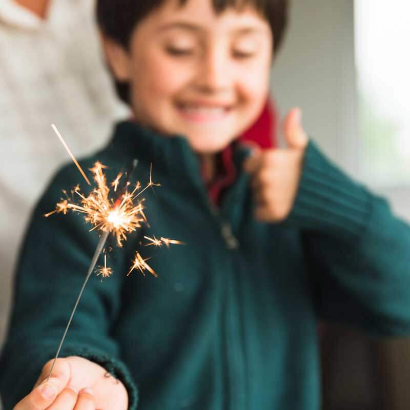 young boy playing with sparkler
