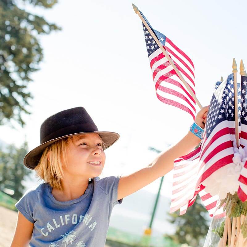 Child with autism doing patriotic act with US flags