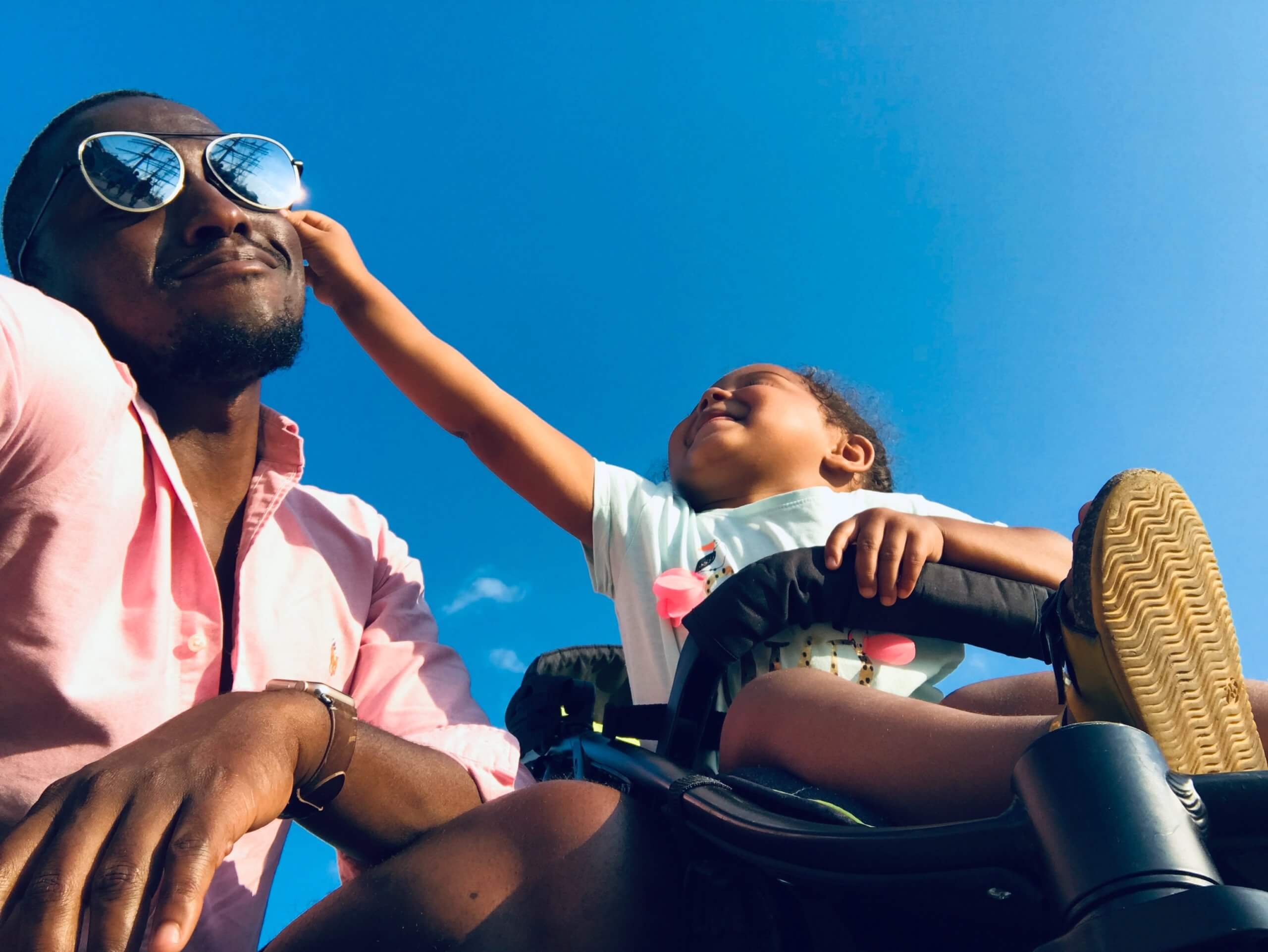Dad with daughter in stroller, happily playing on vacation