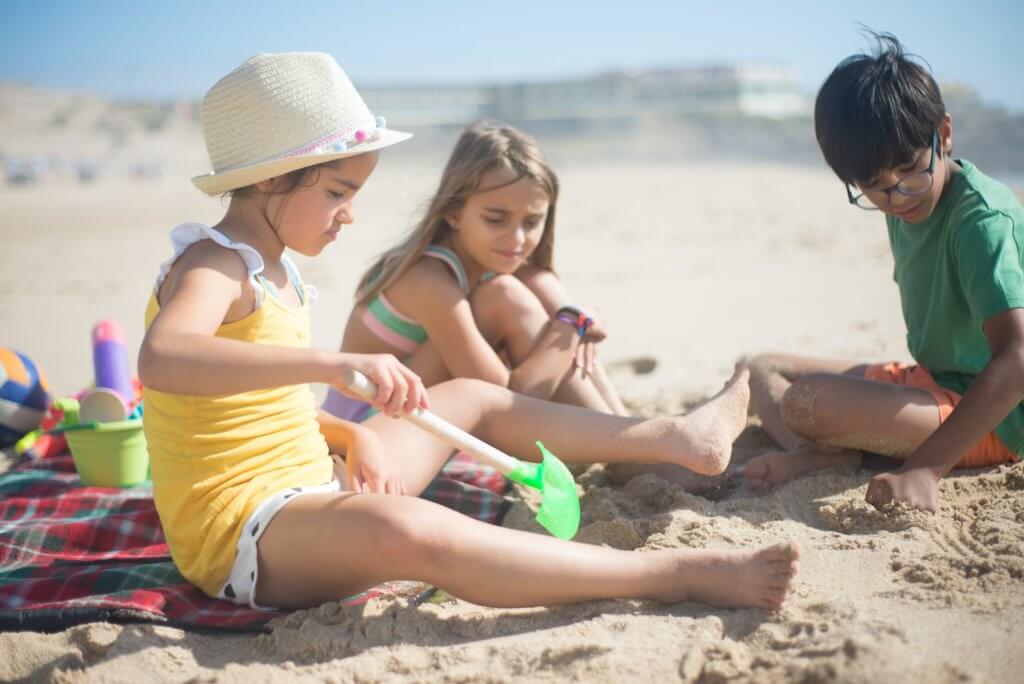 Children playing in the sand at the beach.