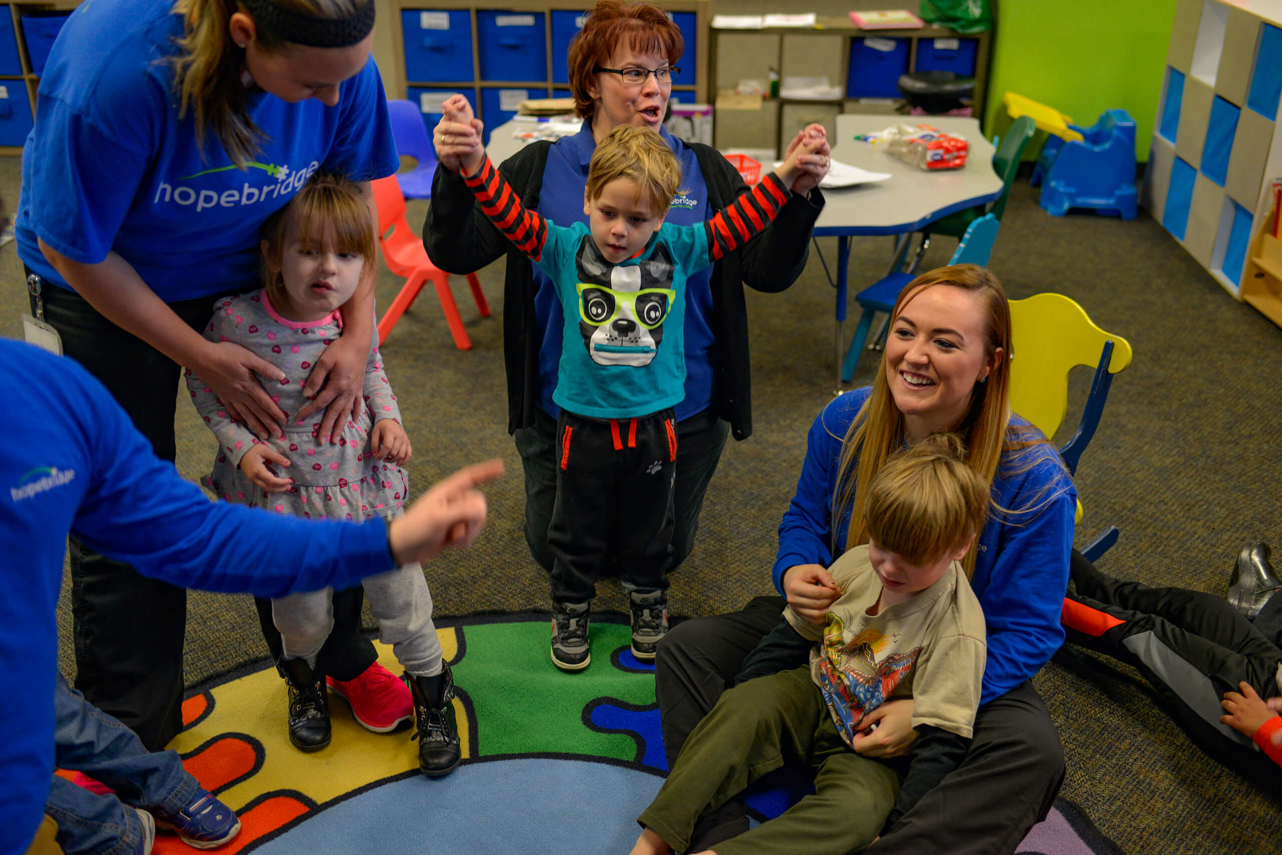 Hopebridge children and therapists participating in circle time at the autism therapy center.