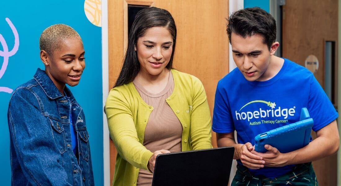 Hopebridge BCBA and other Team Members working together looking at a computer