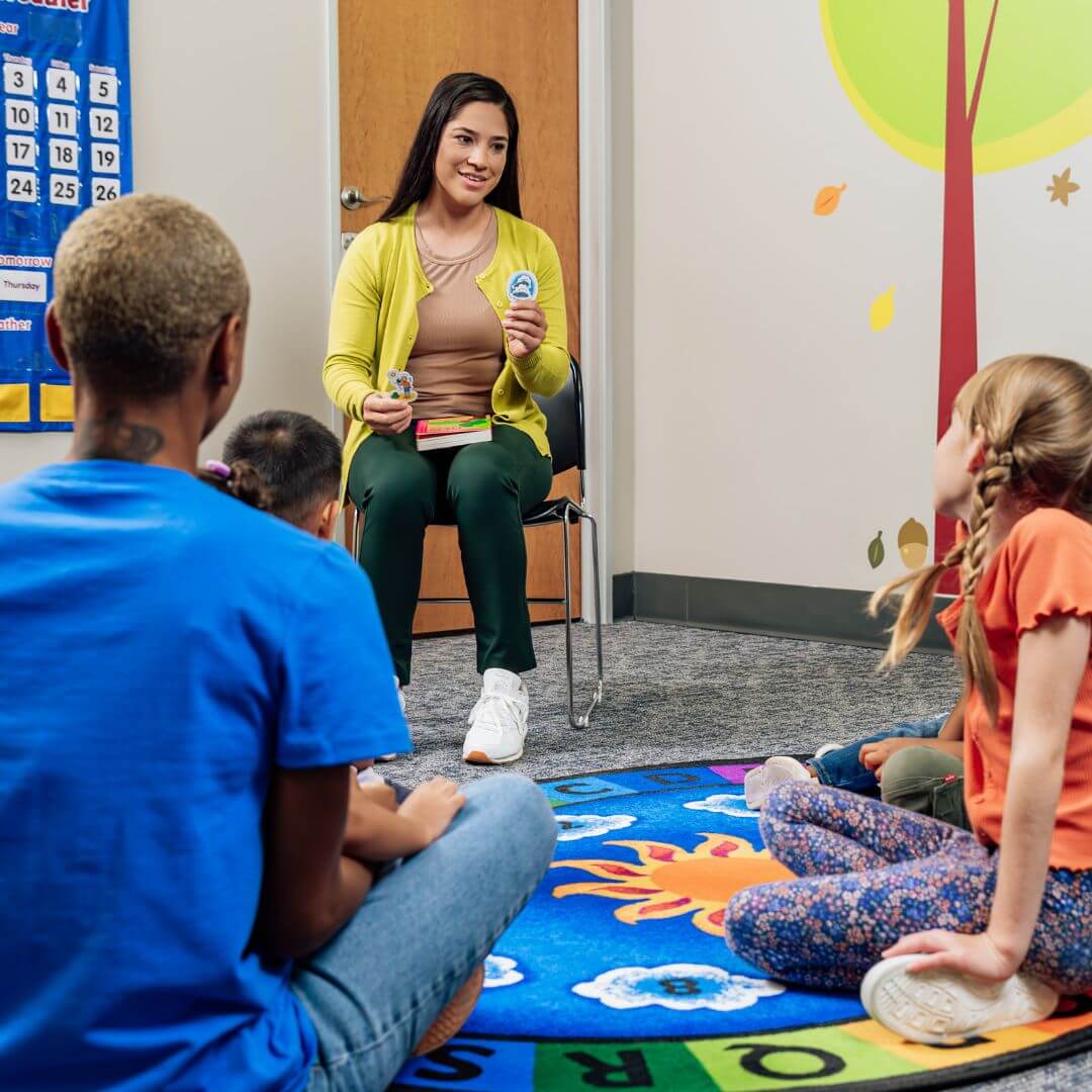 BCBA and RBT sit with children with autism to practice socialization skills