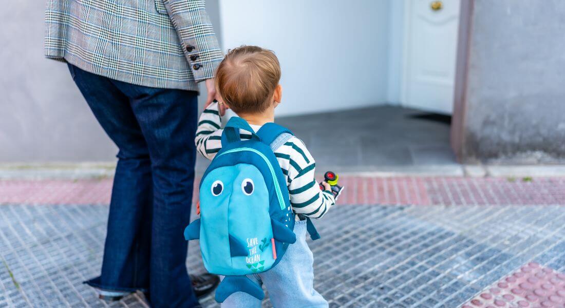 Photo of parent holding child's hand walking into first day of therapy.